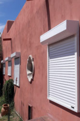 White rolling shutters protecting side windows of Tucson, Arizona home