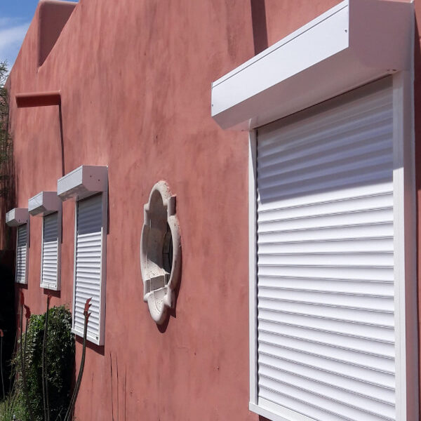 White rolling shutters protecting side windows of Tucson, Arizona home
