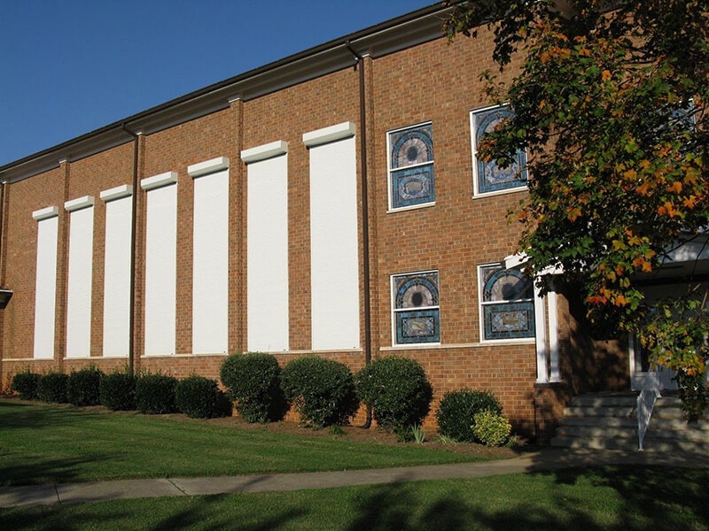 White rolling shutters on side of brick building