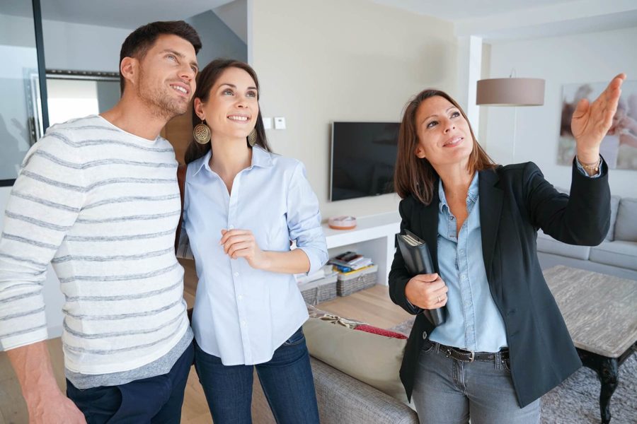 Woman providing in home interior shading consultation to happy couple