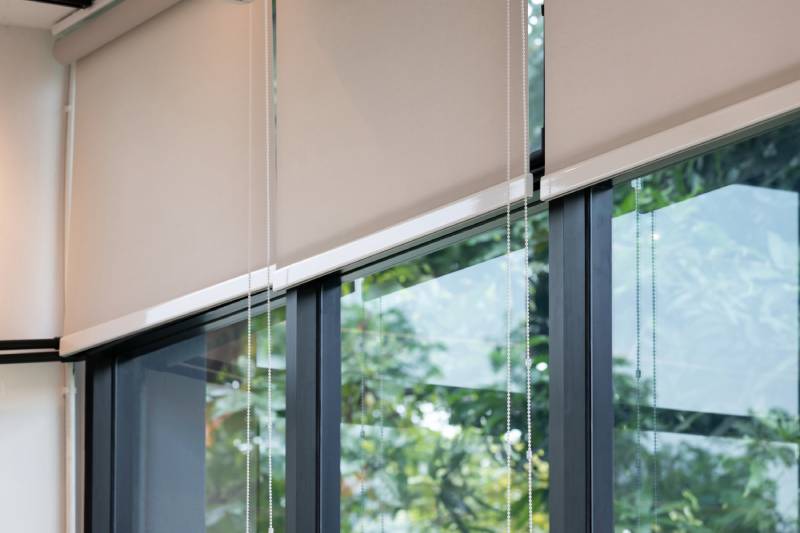 Cream-colored interior solar shades cover the top-half of sectioned windows.