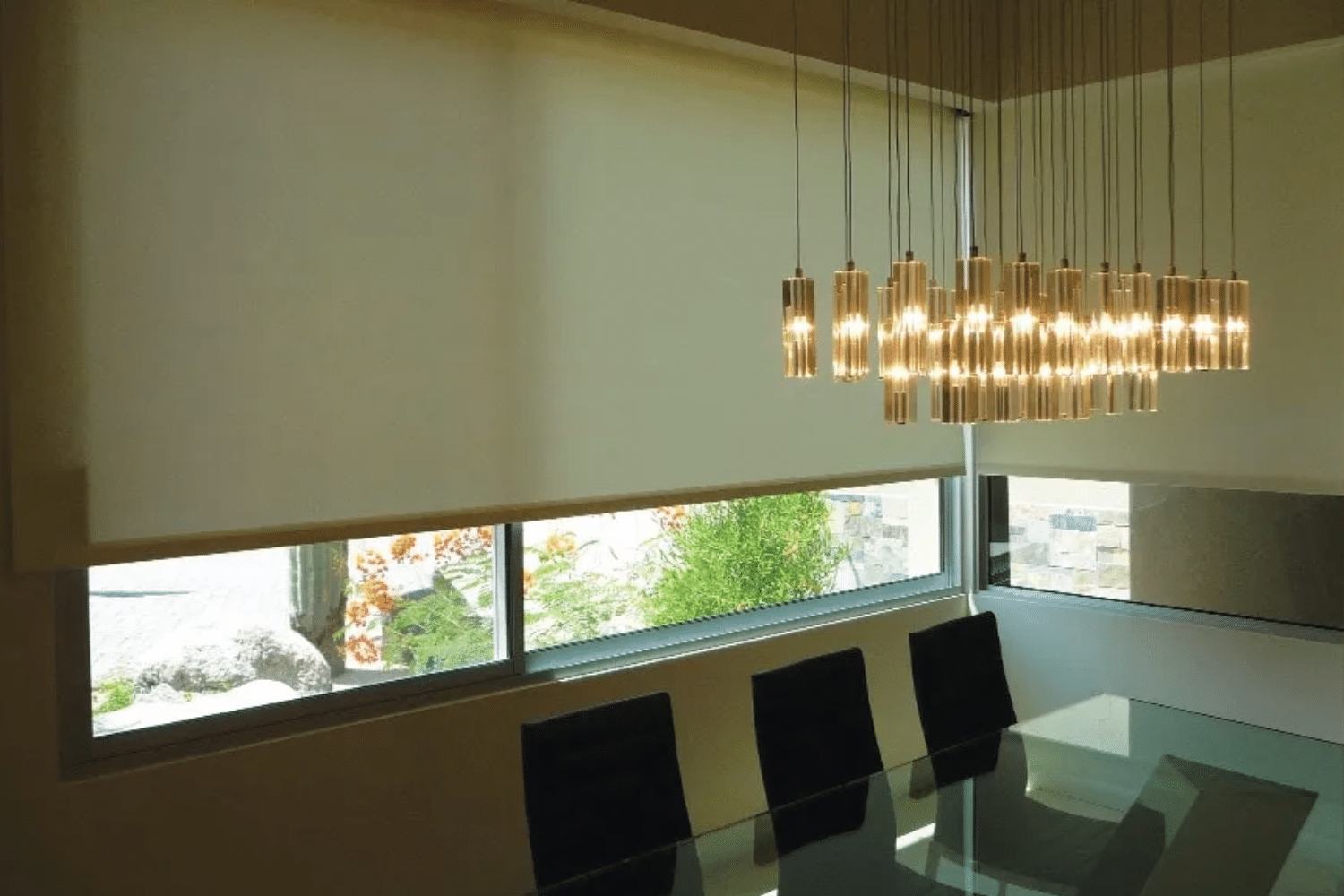 White window shades covering most of a dining room behind the dining room table.