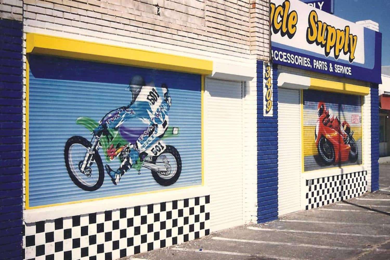 Customized rolling shutters for a Bicycle Supply store. Images of people on motor bikes are painted over the shutters in various colors.